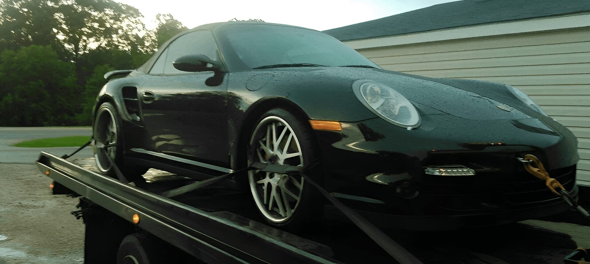 Wet black car being transported