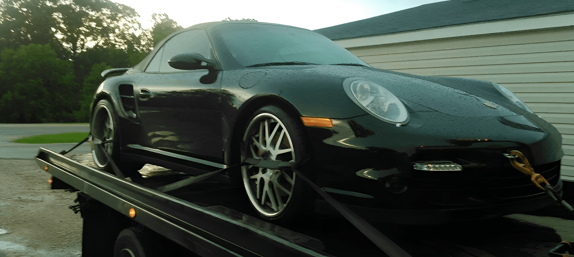 Wet black car being transported