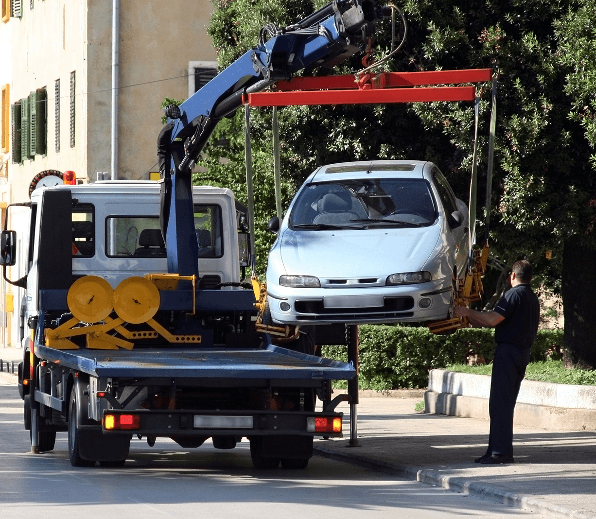 Car being towed by crane